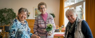 Haus Schillerstraße Drei Seniorinnen lächeln in die Kamera.
